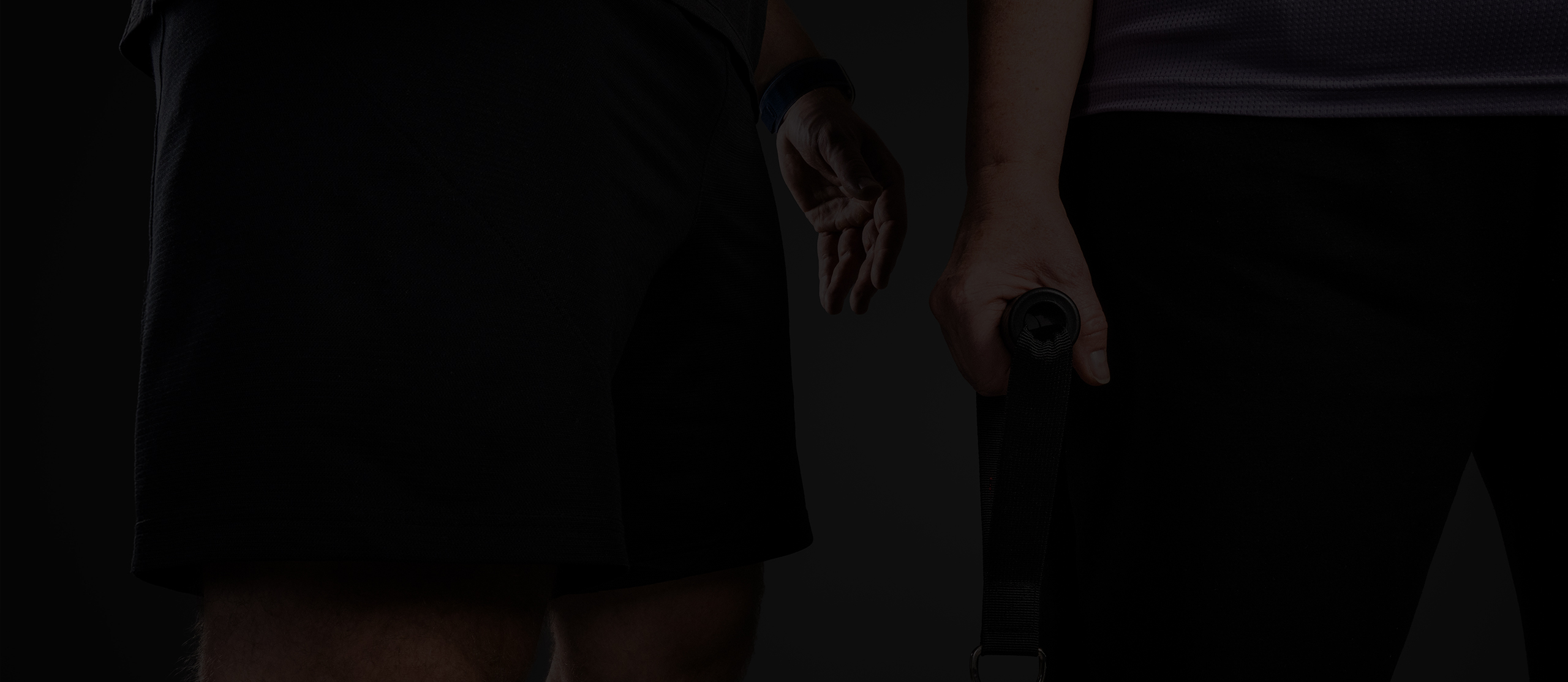 Nahaufnahme von zwei Sportlern in sportlicher Kleidung, einer hält ein Trainingsgerät.