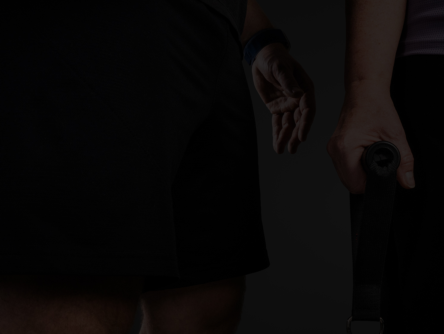 Nahaufnahme von zwei Sportlern in sportlicher Kleidung, einer hält ein Trainingsgerät.